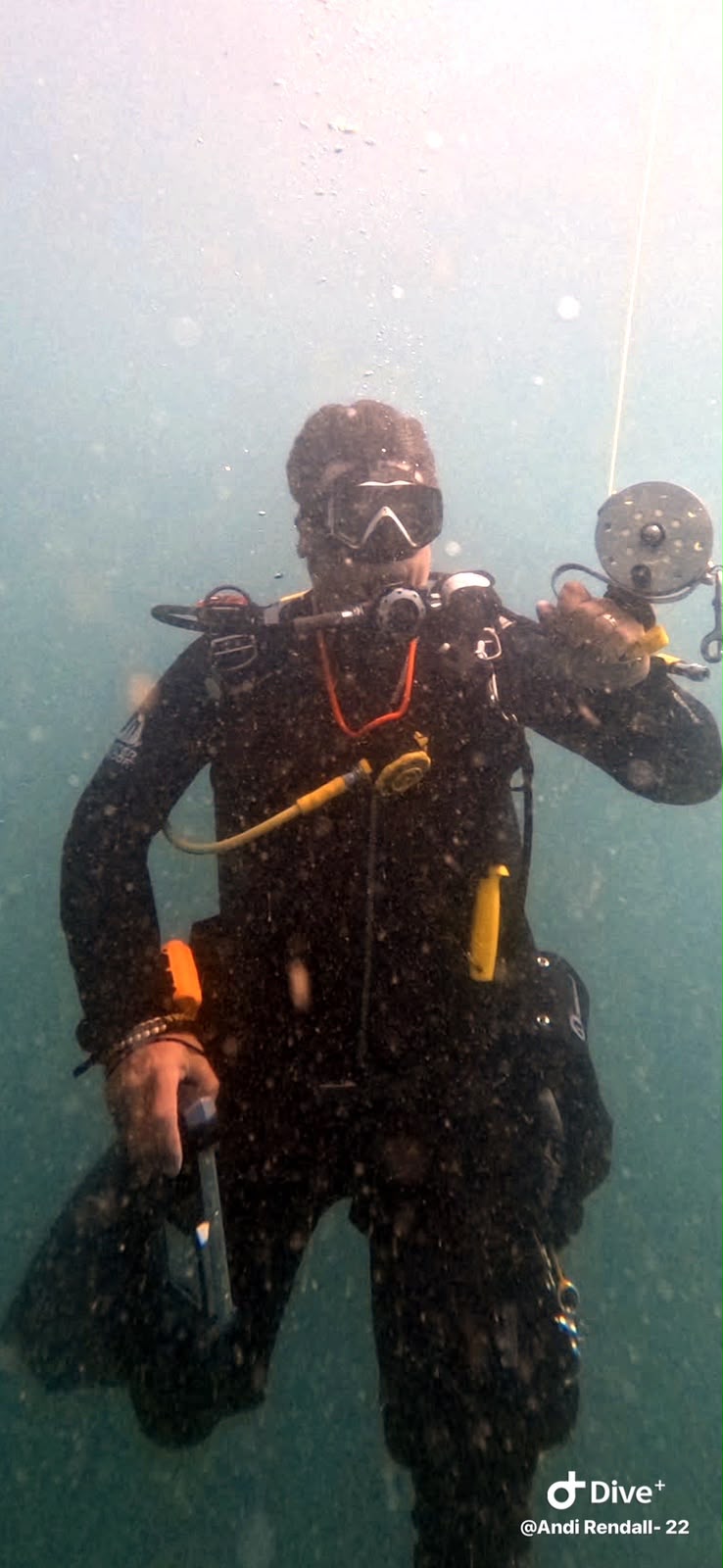 Scuba diver holding a reel underwater